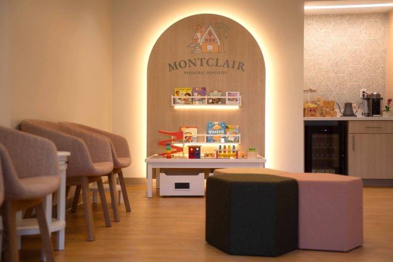 Pediatric dentistry waiting room with toys and seating.