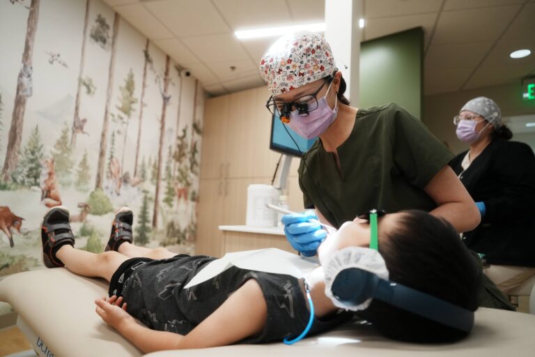 Dentist treats child patient with headphones