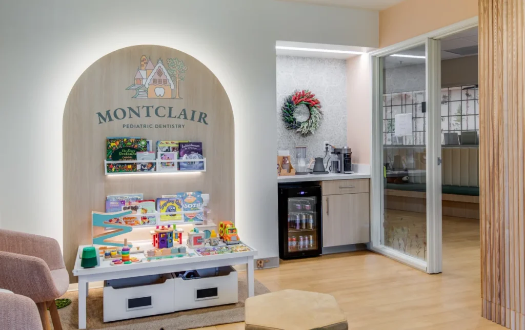 Bright and welcoming pediatric dentistry waiting room featuring toys, books, and a cozy seating area.